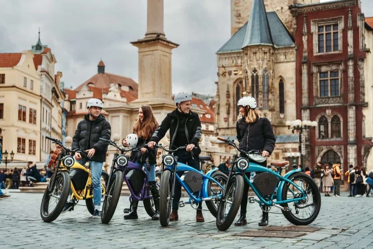 Riders on e-bikes along the Vltava embankment